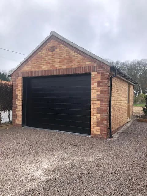 Newly built brick garage with a modern up-and-over door