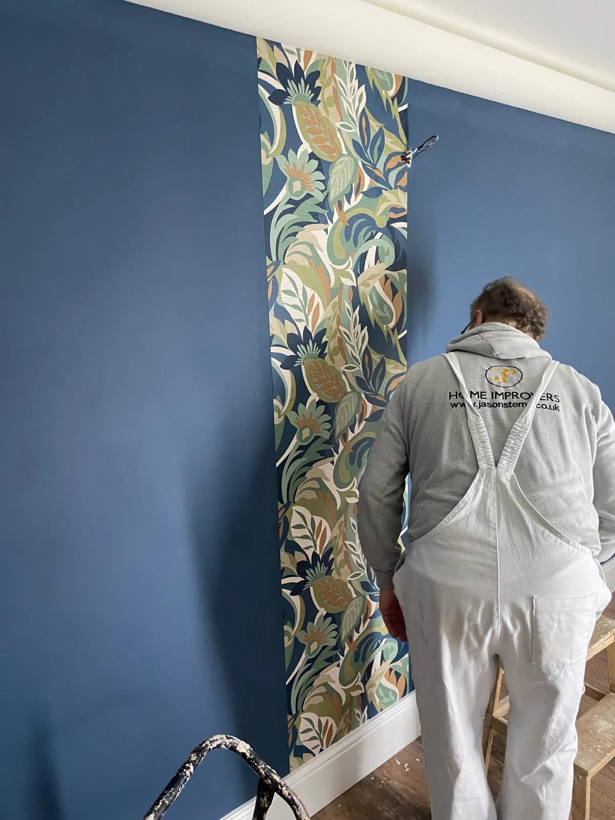 Jason hanging a botanical wallpaper feature wall